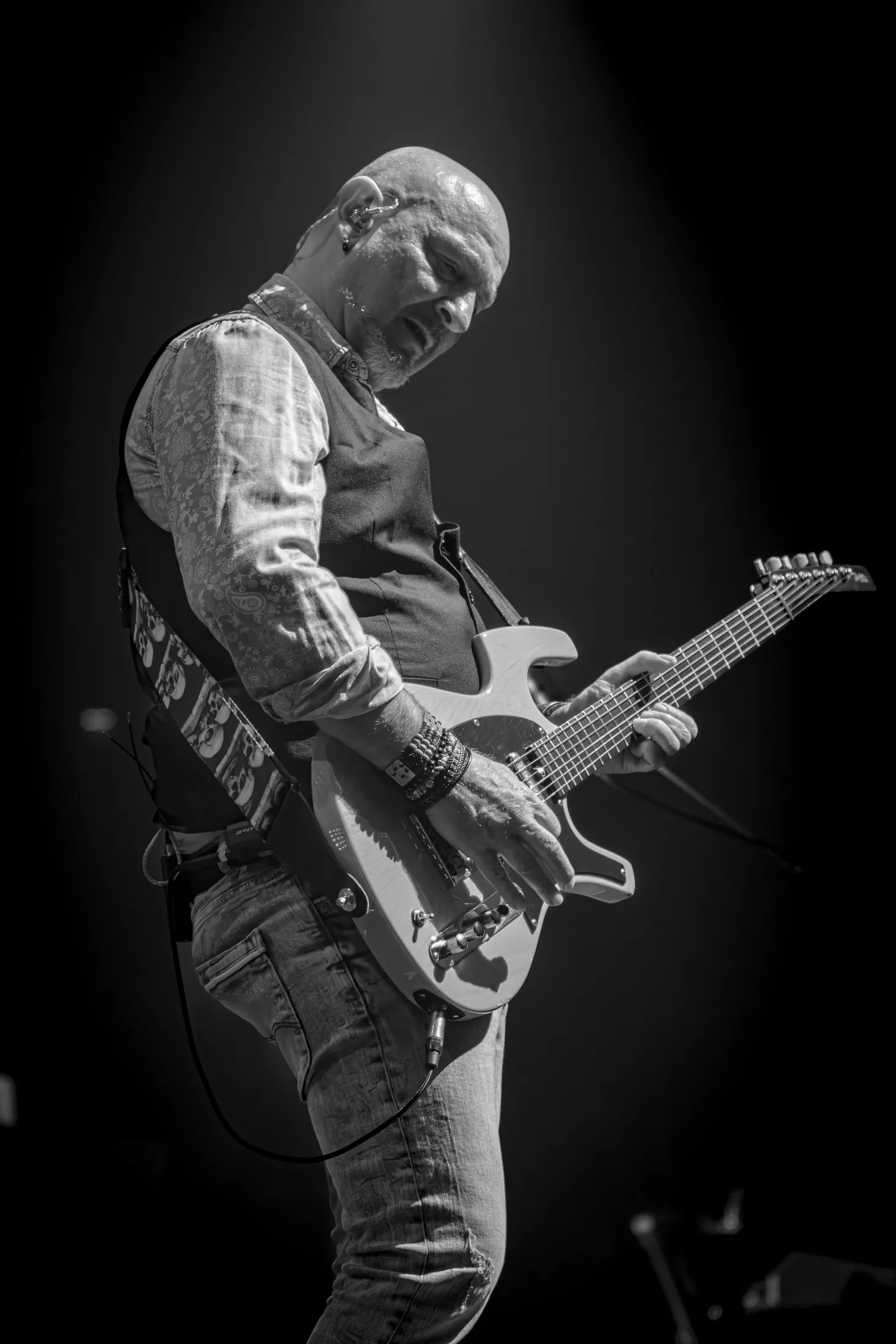 Guitariste de So Floyd en clair-obscur à l'Arena du Pays d'Aix